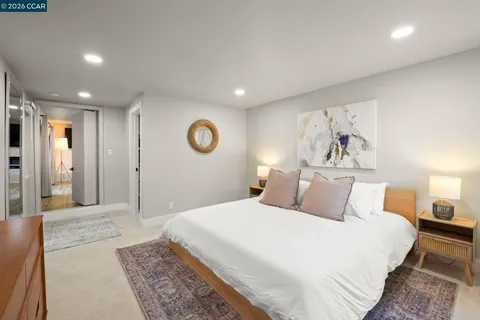 a bedroom with a large bed and a chandelier