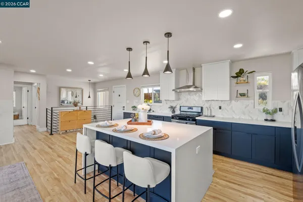 a kitchen with a dining table chairs and wooden floor