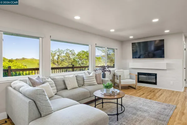 a living room with furniture fireplace and a large window