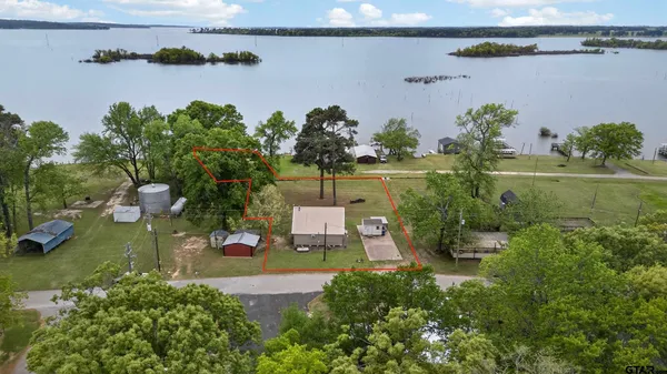 an aerial view of a house with a yard and lake view