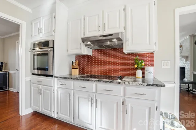 a kitchen with stainless steel appliances granite countertop a sink a stove and a refrigerator