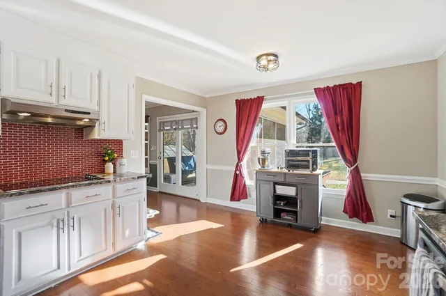a view of a kitchen with furniture and wooden floor