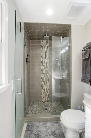 a bathroom with a shower a toilet and a sink