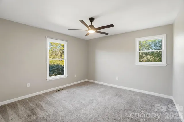 an empty room with a window and a fan