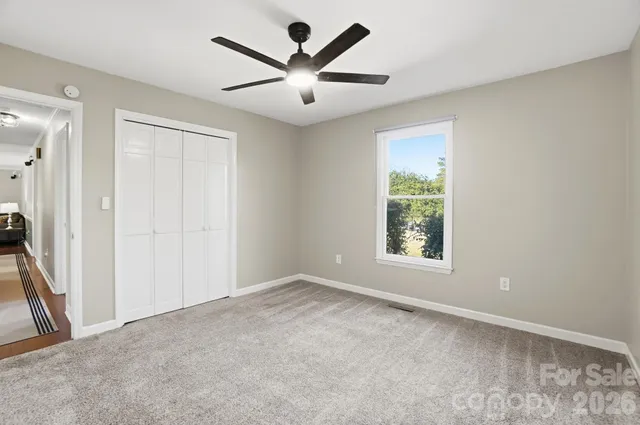 an empty room with a window and a fan