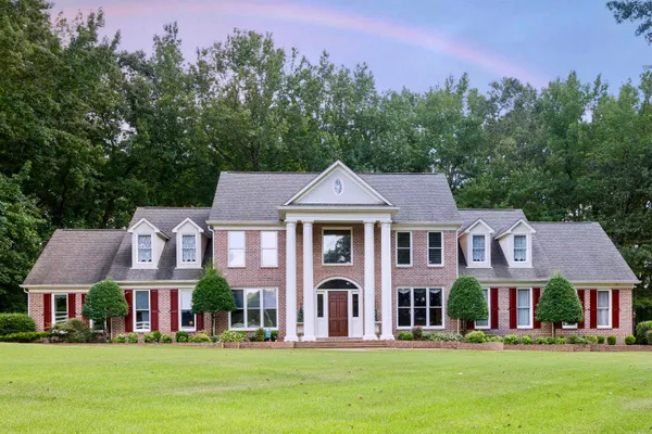 a front view of residential houses with yard and green space