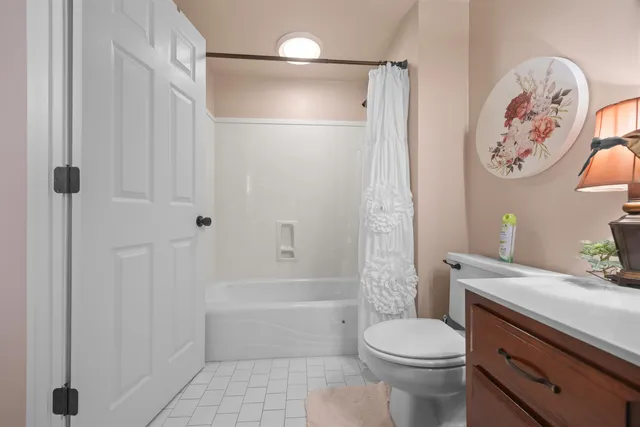 a spacious bedroom with a bed and a chandelier