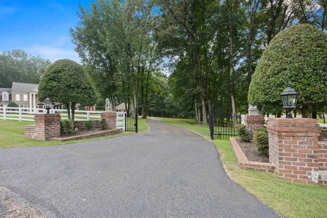 a front view of a house with yard and green space