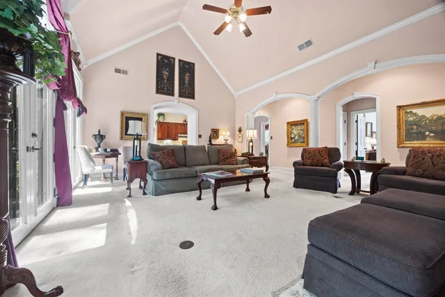 a living room with furniture a large window and a chandelier