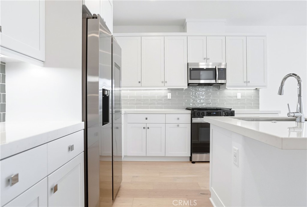3140 Cove Street Rancho Mission Viejo, CA 92694 - Photo 7 of 69 a kitchen with stainless steel appliances granite countertop a refrigerator sink and white cabinets