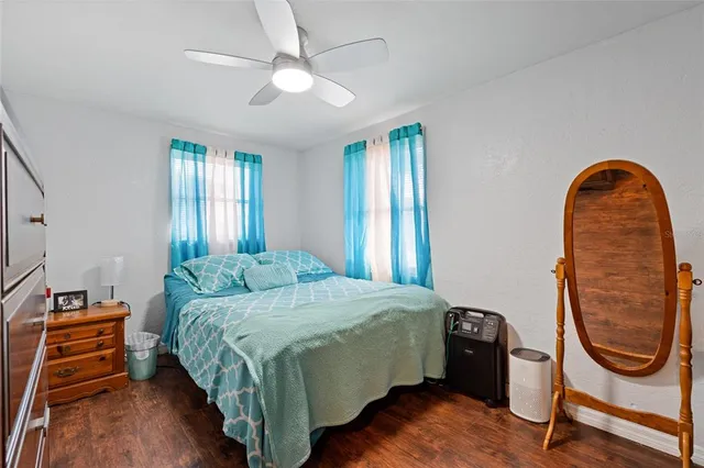 a bedroom with a bed a dresser and window