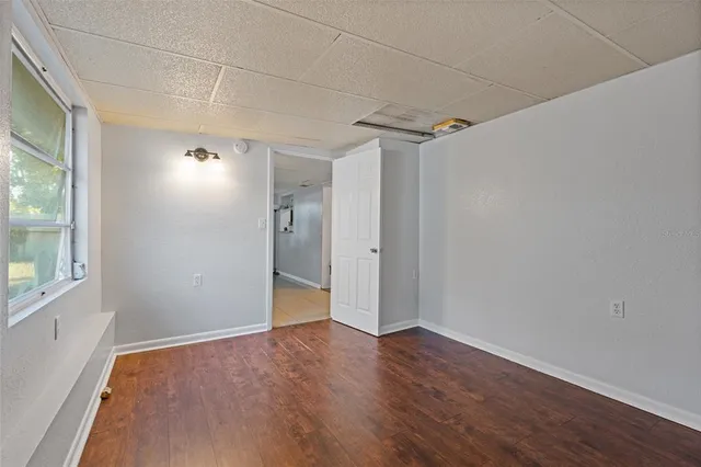 a view of empty room with wooden floor and fan