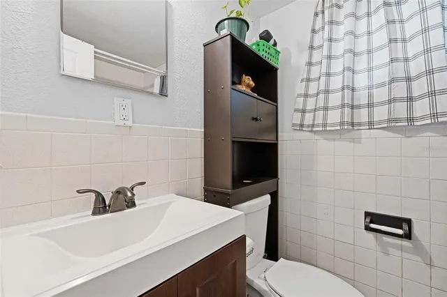 a bathroom with a sink a toilet and a mirror