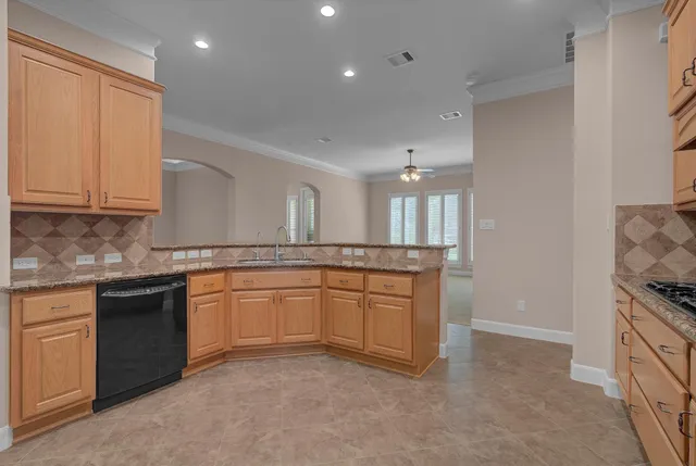 a large kitchen with stainless steel appliances granite countertop a stove a sink and a refrigerator
