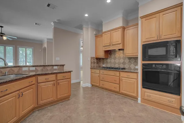 a kitchen with granite countertop white cabinets stainless steel appliances and a sink