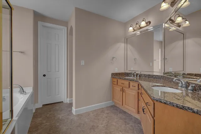 a bathroom with a granite countertop sink double vanity and a mirror