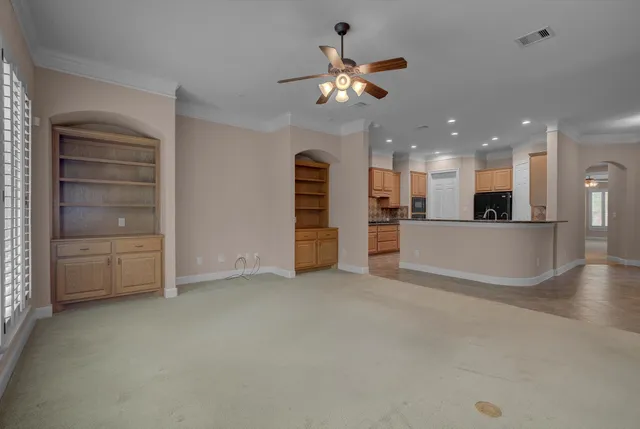 a view of a livingroom with a furniture a ceiling fan and window