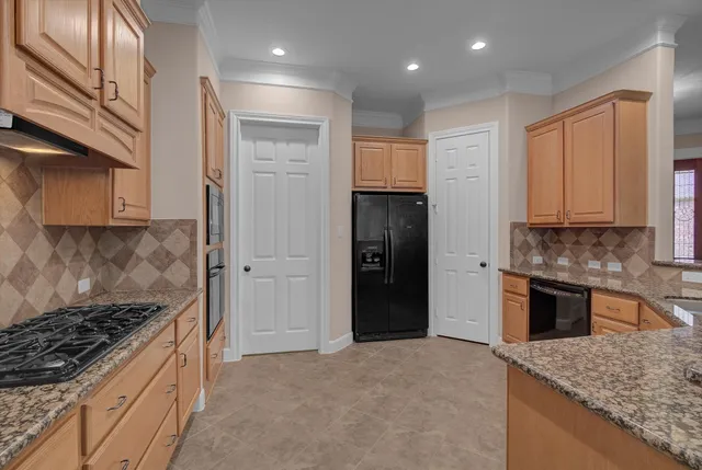 a kitchen with stainless steel appliances granite countertop a stove a sink and a refrigerator