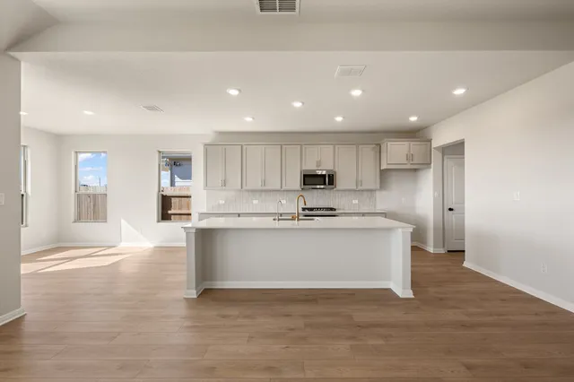 a kitchen with stainless steel appliances a white stove top oven and cabinets