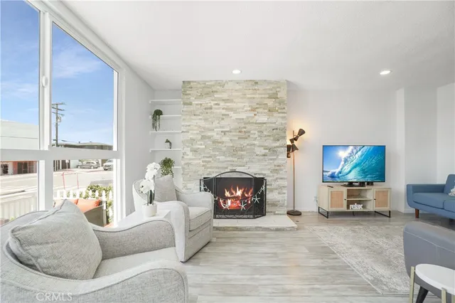 a living room with furniture a flat screen tv and a fireplace