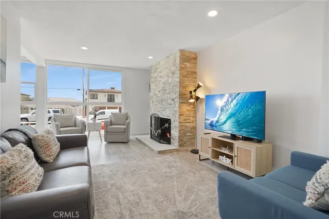a living room with furniture a flat screen tv and a fireplace