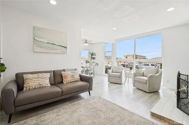 a living room with furniture and a view of kitchen