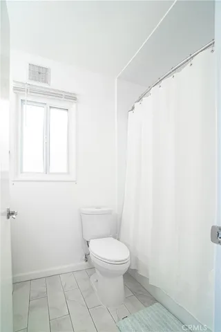 a white toilet sitting next to a shower curtain