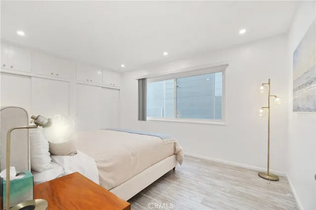 a spacious bedroom with a bed and a lamp