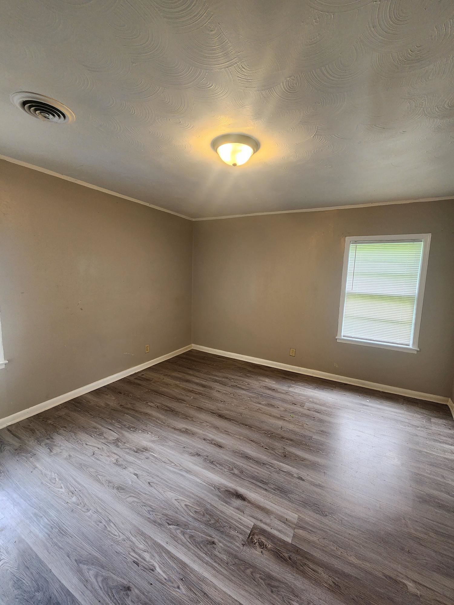 3645 Brompton Road Memphis, TN 38118 - Photo 3 of 17 a view of an empty room with wooden floor and a window