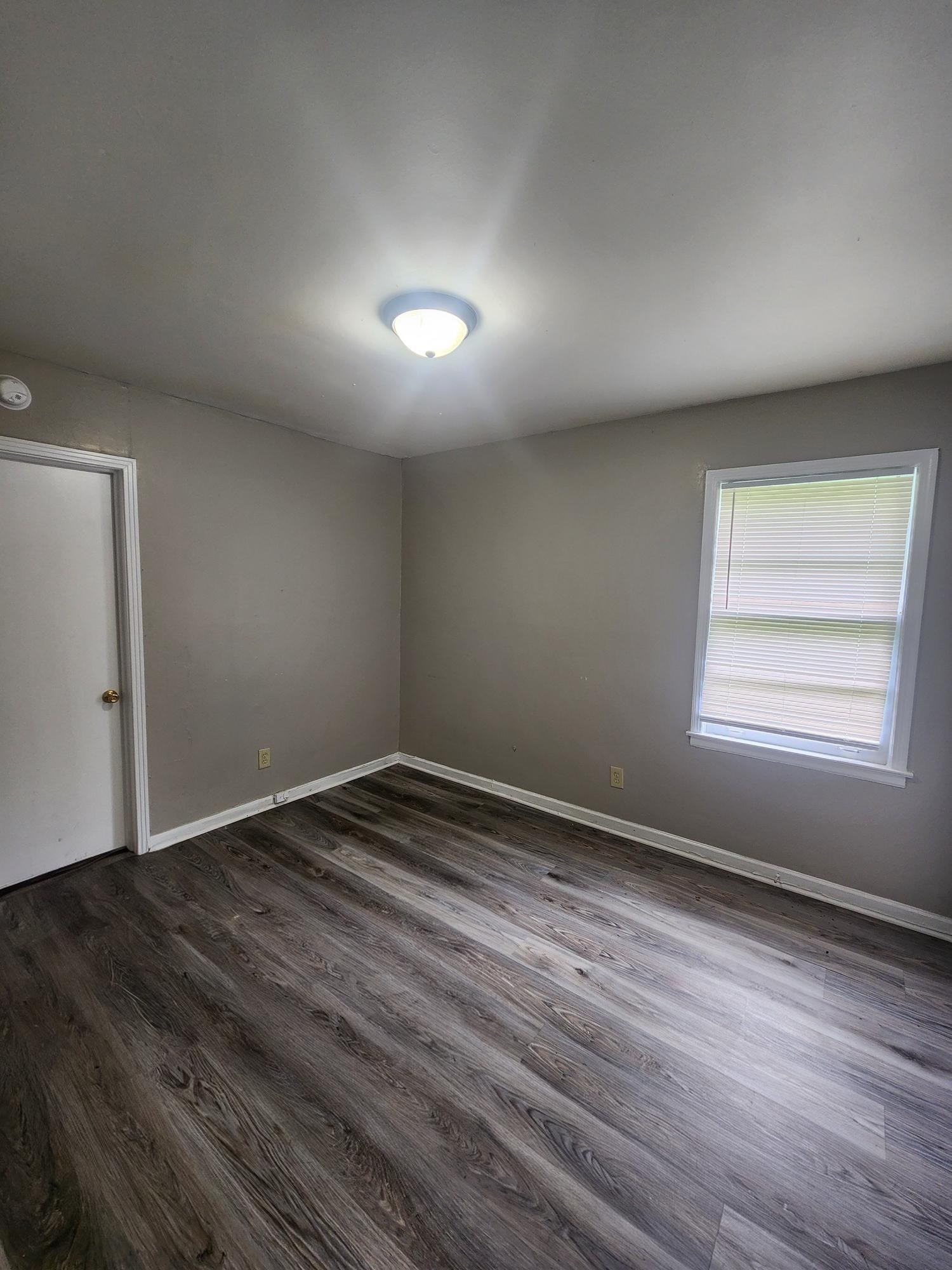 3645 Brompton Road Memphis, TN 38118 - Photo 5 of 17 an empty room with wooden floor and windows