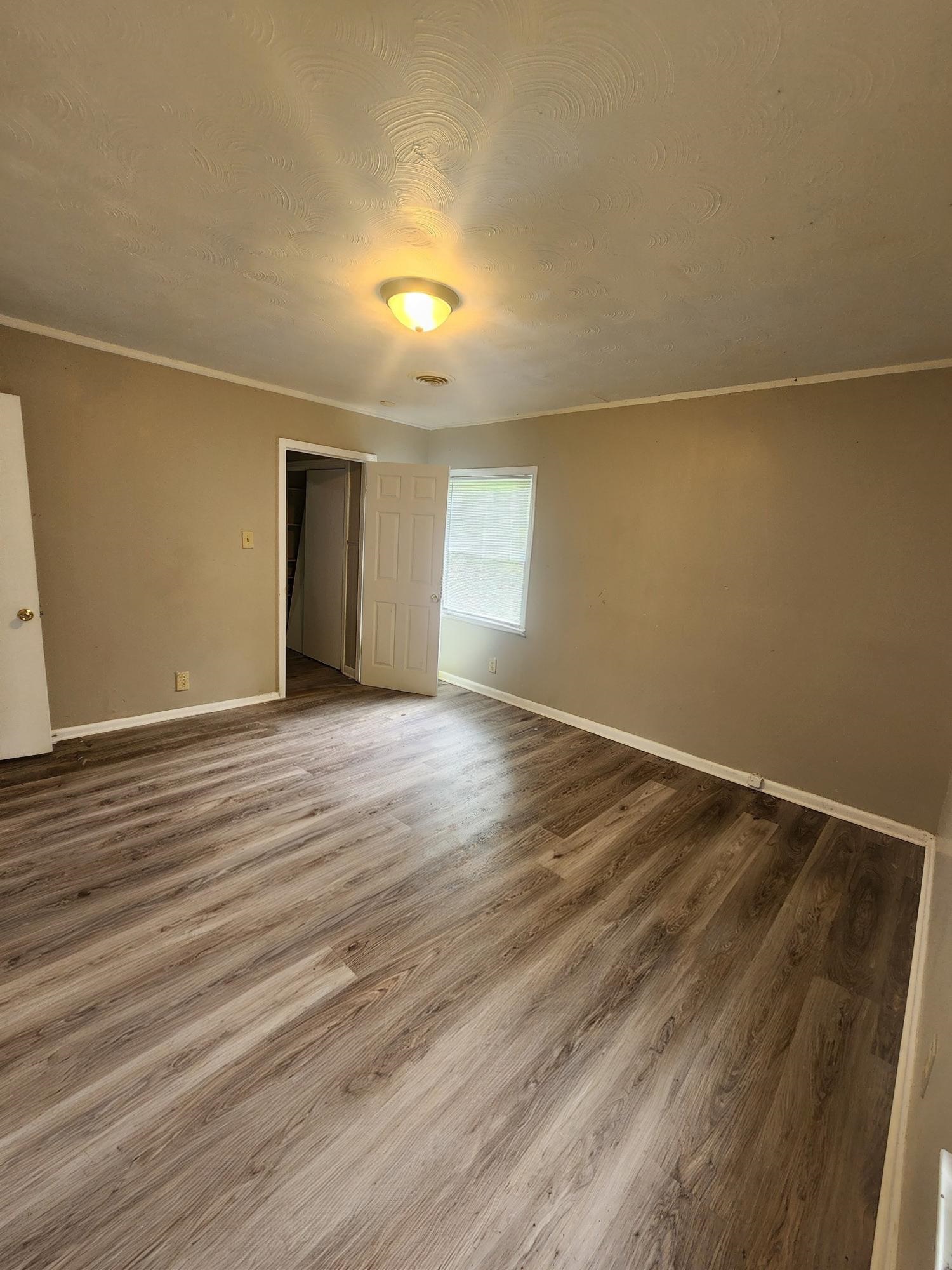 3645 Brompton Road Memphis, TN 38118 - Photo 7 of 17 an empty room with wooden floor and windows