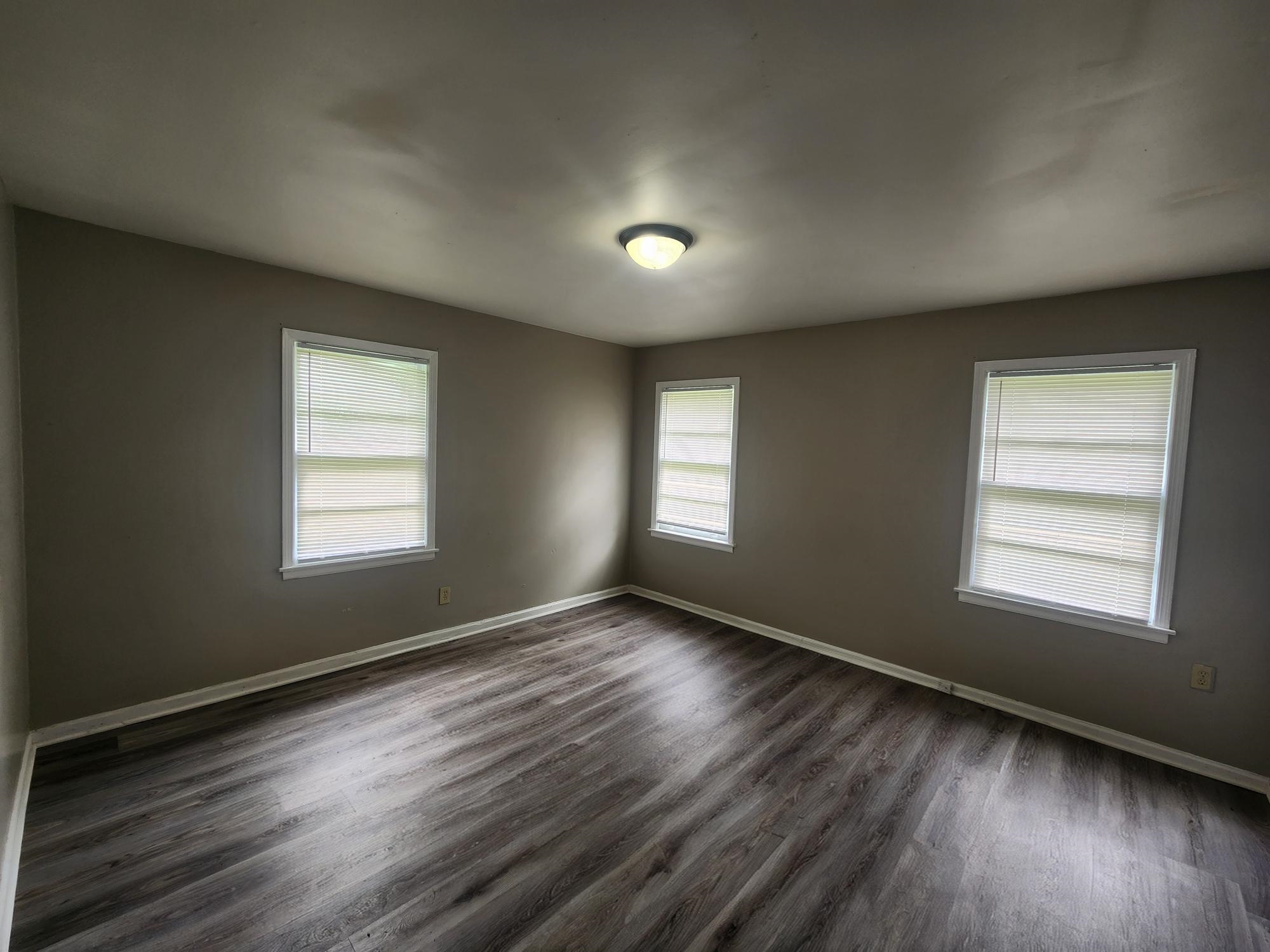 3645 Brompton Road Memphis, TN 38118 - Photo 8 of 17 an empty room with wooden floor and windows