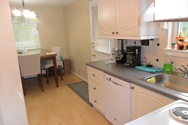 a kitchen with white cabinets and sink