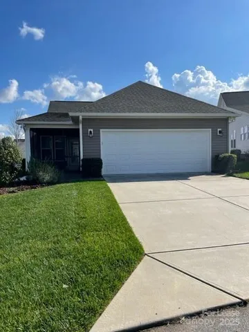 a front view of house with yard and garage