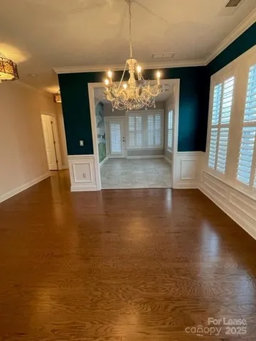 a view of a room with wooden floor and chandelier