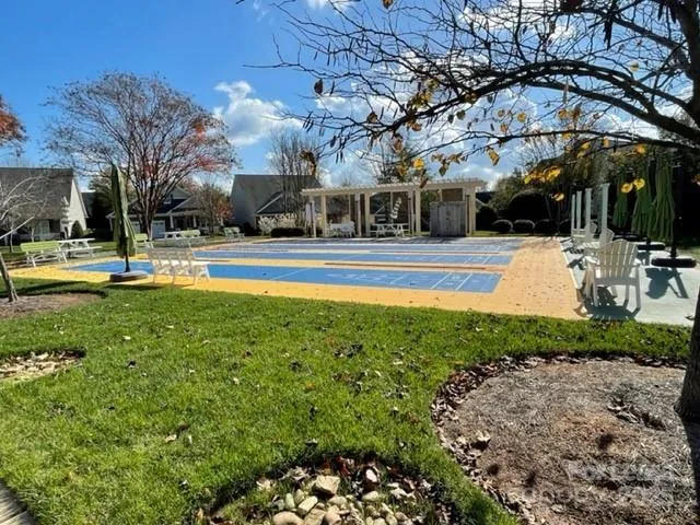 a view of a swimming pool with lawn chairs under an umbrella