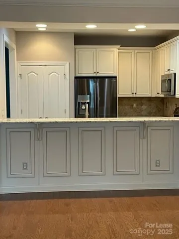 a kitchen with stainless steel appliances granite countertop a refrigerator and a sink