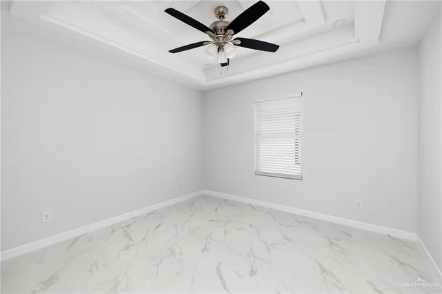 an empty room with a window and a fan