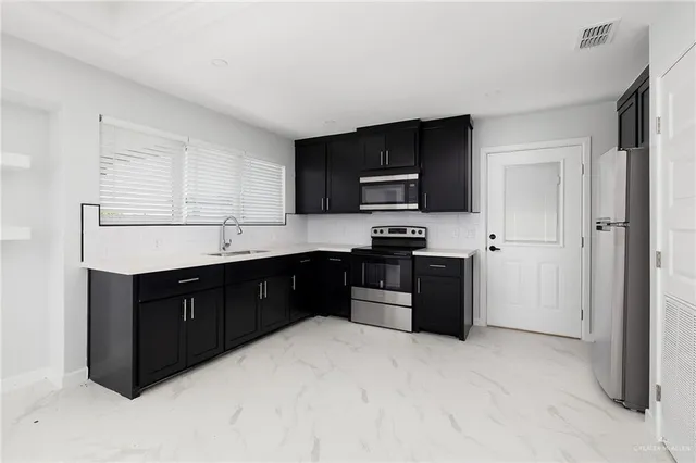 a kitchen with a refrigerator stove and sink