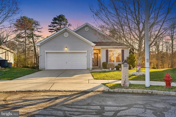 a view of a house with a large tree and wooden fence