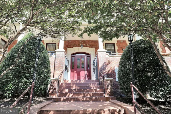 a front view of a house with a tree