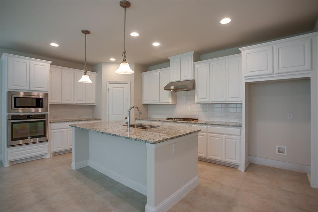 3412 Damsel Sauvage Lane Lewisville, TX 75056 - Photo 11 of 28 a kitchen with stainless steel appliances granite countertop a sink and white cabinets