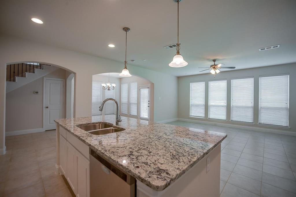 3412 Damsel Sauvage Lane Lewisville, TX 75056 - Photo 12 of 28 a kitchen with kitchen island granite countertop a stove and a sink