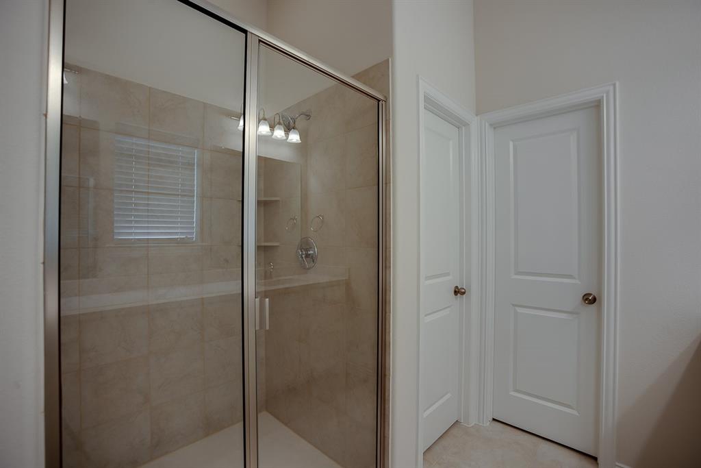 3412 Damsel Sauvage Lane Lewisville, TX 75056 - Photo 25 of 28 a bathroom with a shower and a glass door