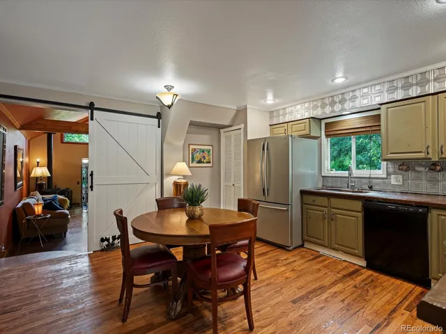 a kitchen with a table chairs sink and refrigerator