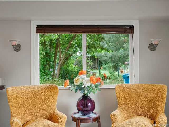a living room with patio furniture and a potted plant