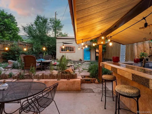 a patio with a table and chairs and potted plants
