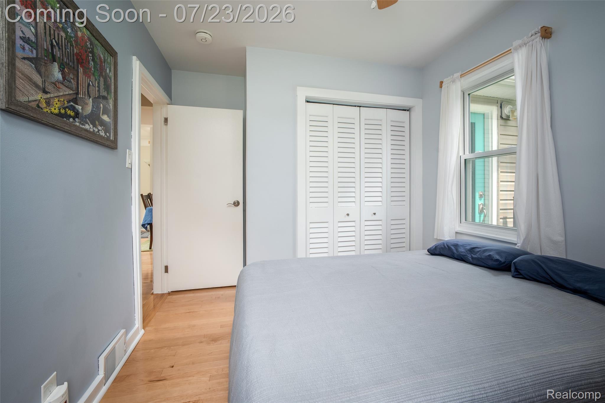 829 Francis Street Rochester, MI 48307 - Photo 10 of 25 Bedroom featuring wood-finish flooring, light blue wall paint, white trim, and a window with white curtains