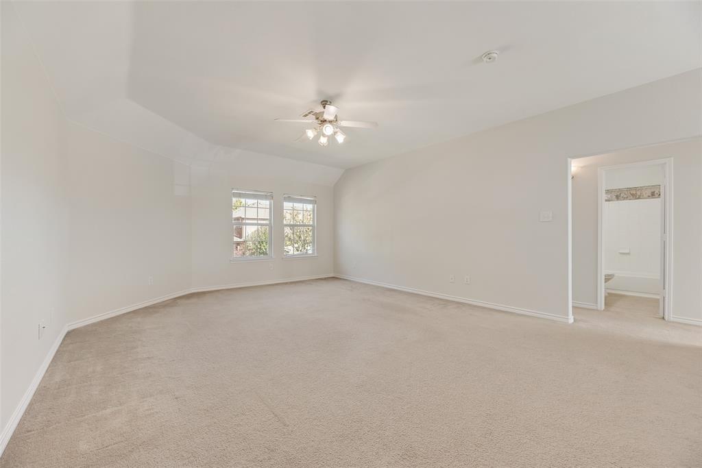 8004 Laughing Waters Trail McKinney, TX 75070 - Photo 16 of 24 an empty room with a chandelier fan and windows