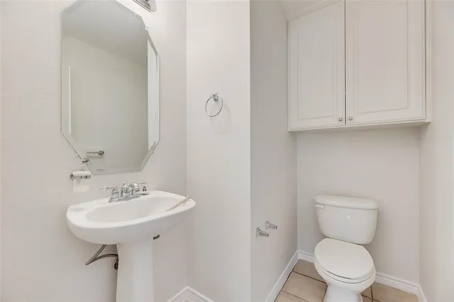 a bathroom with a toilet sink and a mirror